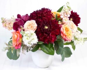ruby red dahlias with peach and pink flowers in vase