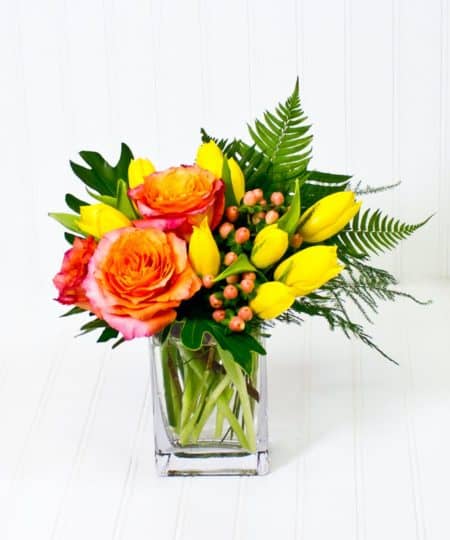This cheerful design of yellow tulips and fragrant Free Spirit garden roses is bound to brighten anyone's day.