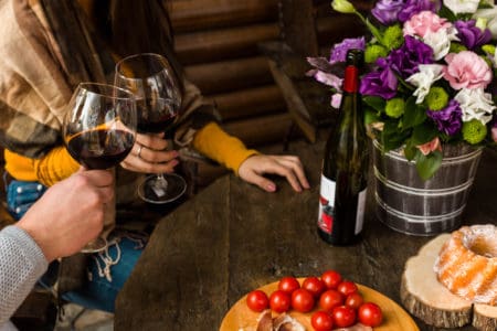Romantic couple enjoying lunch at home or restaurant, concept love, relationship and romantic, happy couple celebrating and making cheers with glasses of red wine,rustic ambient